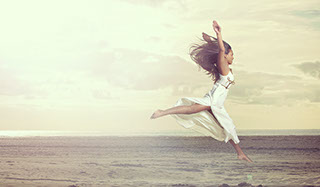 Indian dancer jumping in the air on the beach